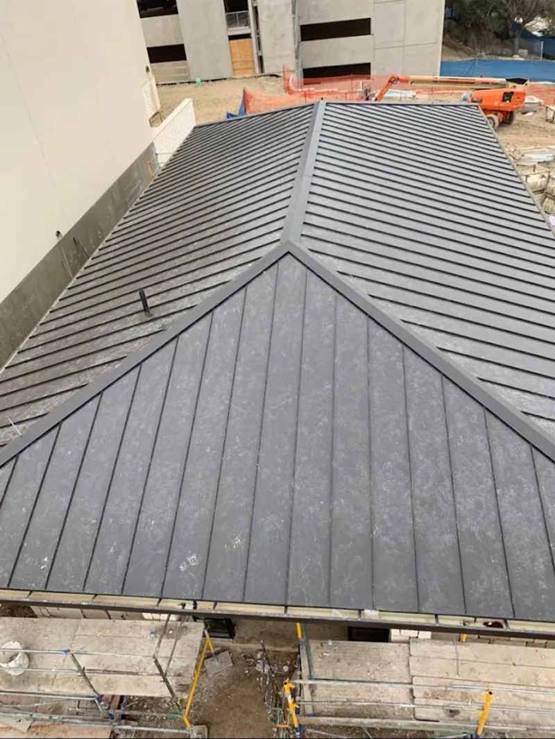 Commercial metal roof construction with crane equipment in West St. Paul